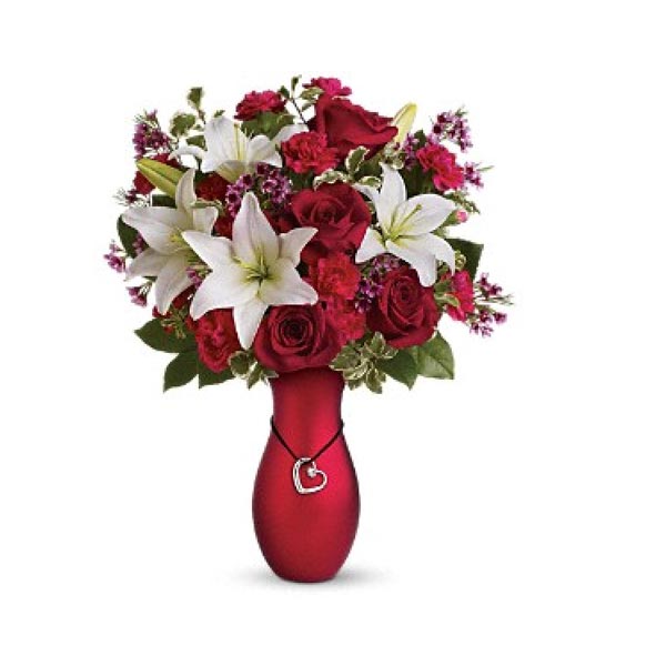 Tout simplement WOW un magnifique bouquet de rose rouge et de lys blanc. Le  tout bien agencé dans un vase de céramique rouge agrémenté d'un pendentif  avec un coeur totalisant 1 carat
